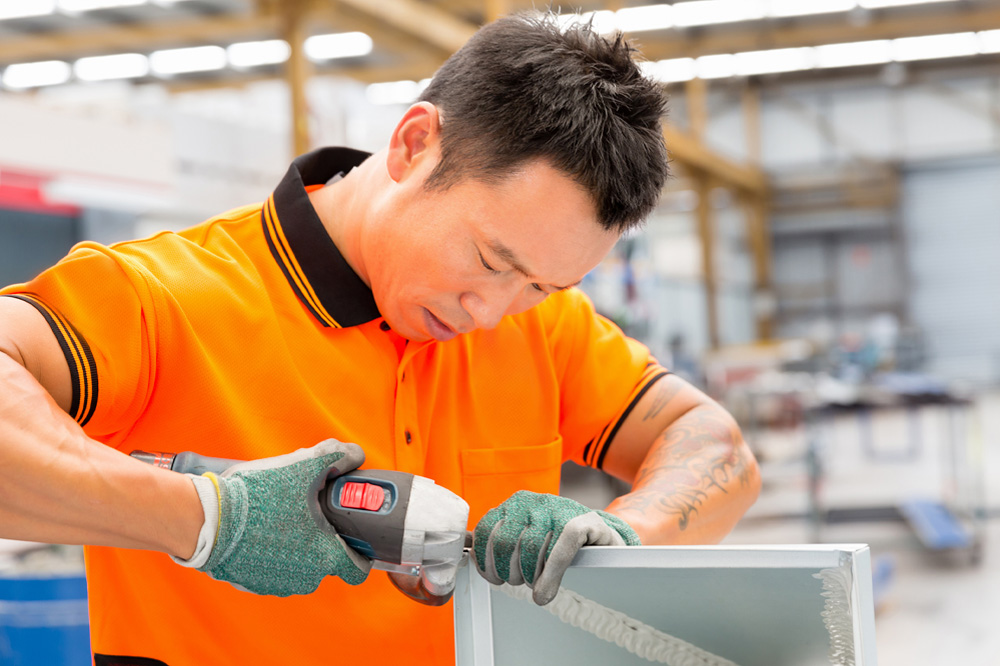 Asian worker in production plant working on the factory floor.