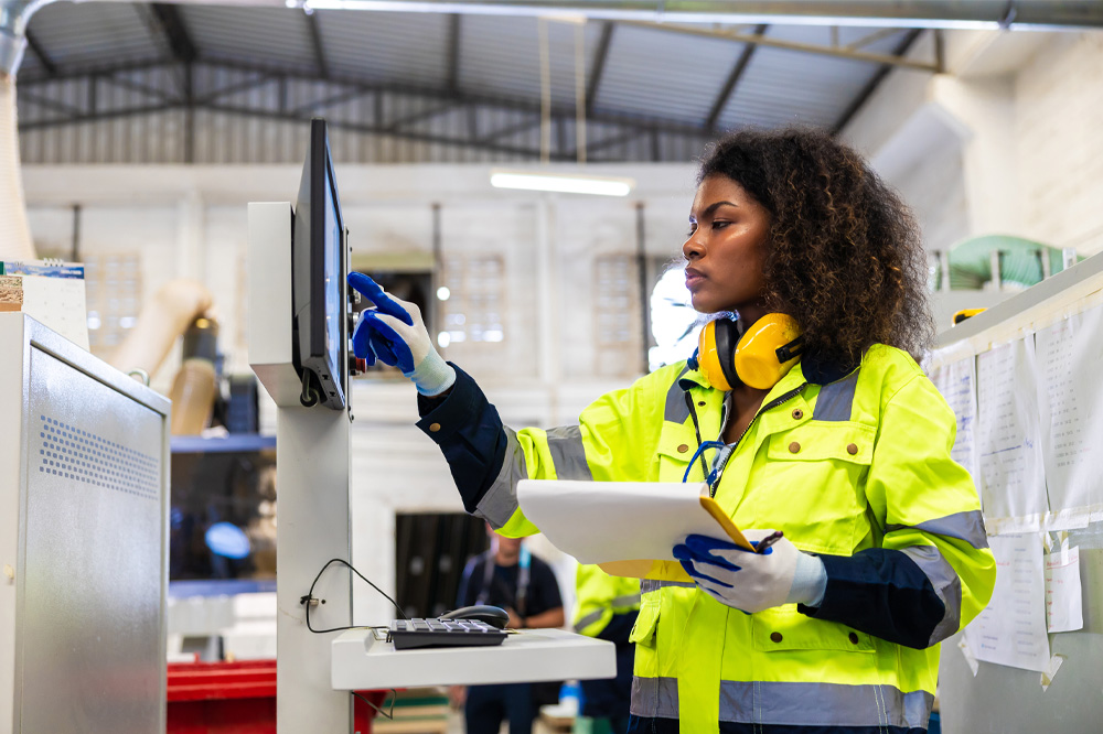 Female worker operating a cutting machine in a factor.